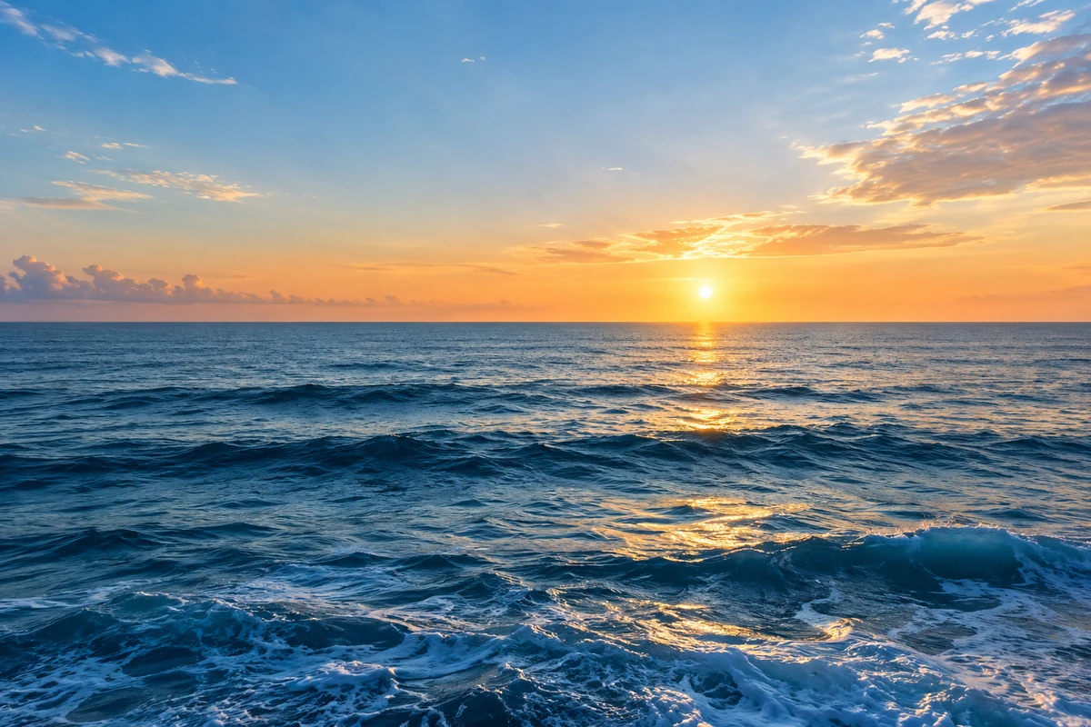 Un océan paisible et son horizon lumineux au lever du soleil.